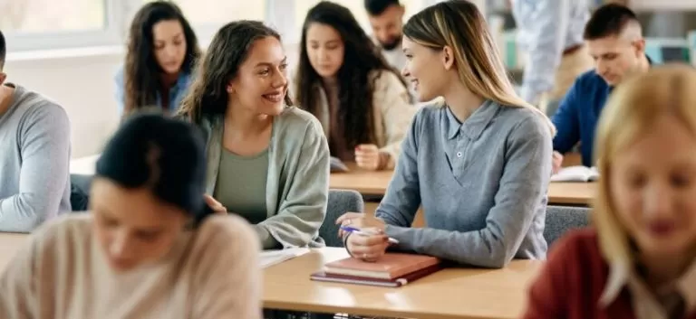 Happy female students talking during a class at the university.